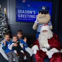 Two boys with baby sister anchor up with Santa and Louie